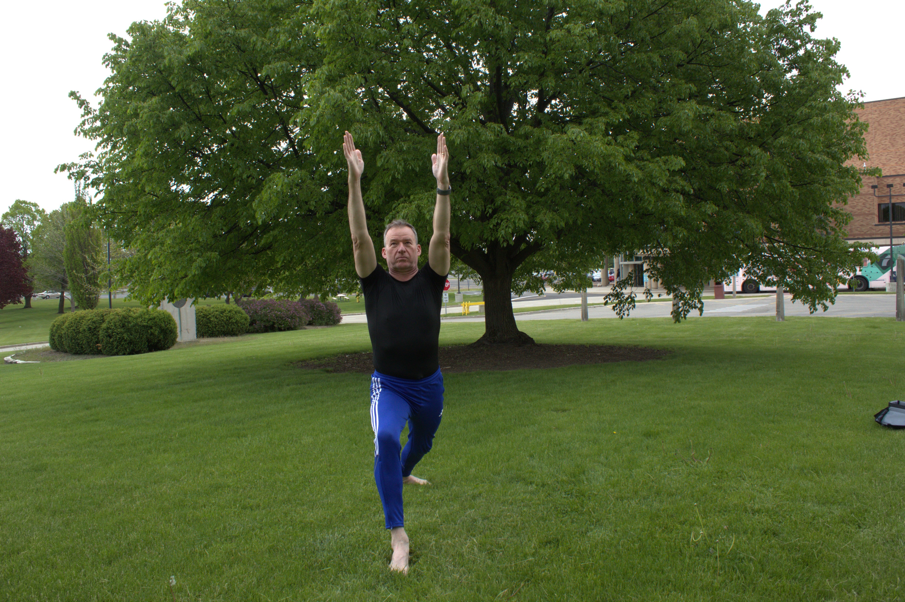 Roy practising Warrior One pose outdoors